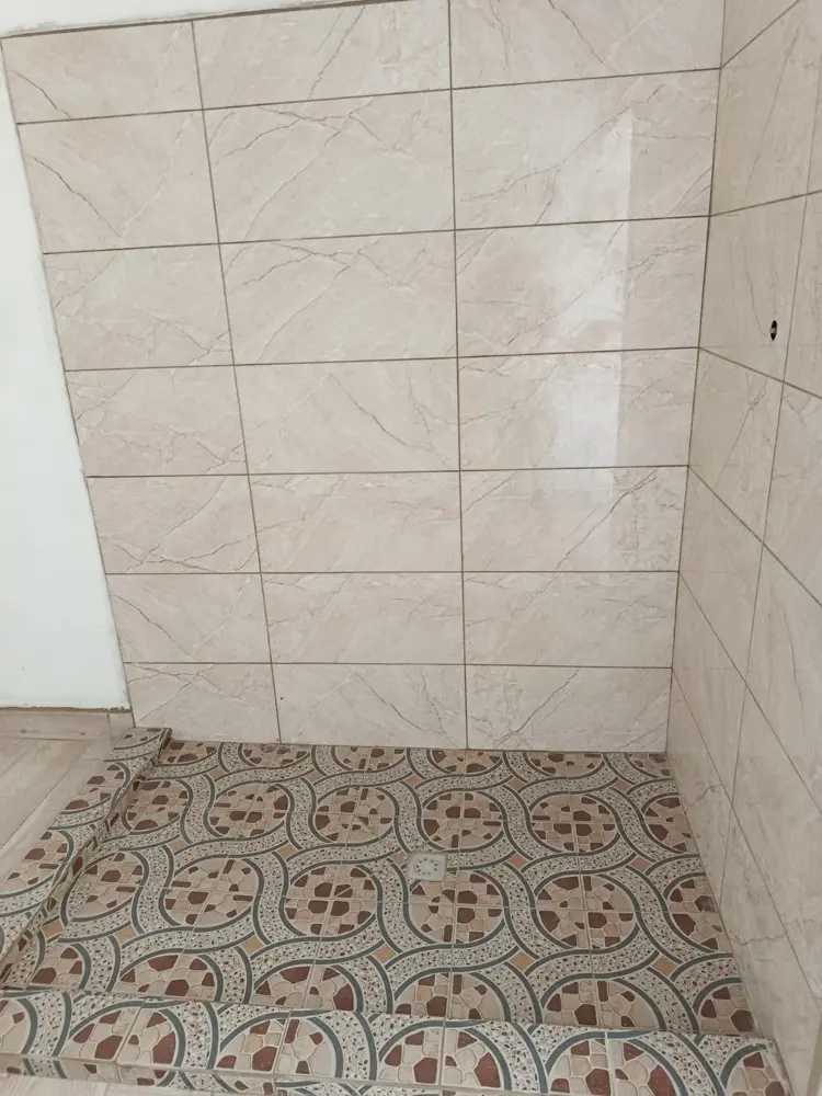 Encuentro entre el azulejo tipo m&aacute;rmol de la pared y el piso de cer&aacute;mica decorada