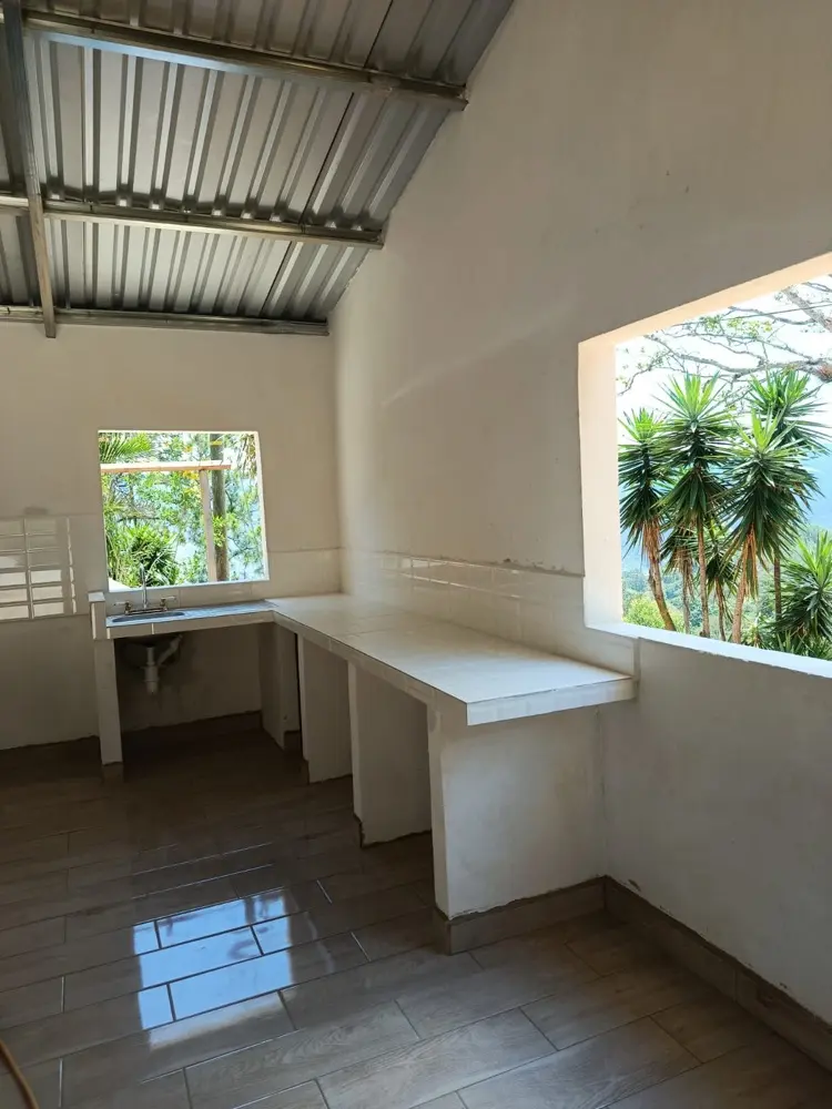 Cocina terminada con poyo en L revestido en cer&aacute;mica, piso nuevo y techo de l&aacute;mina