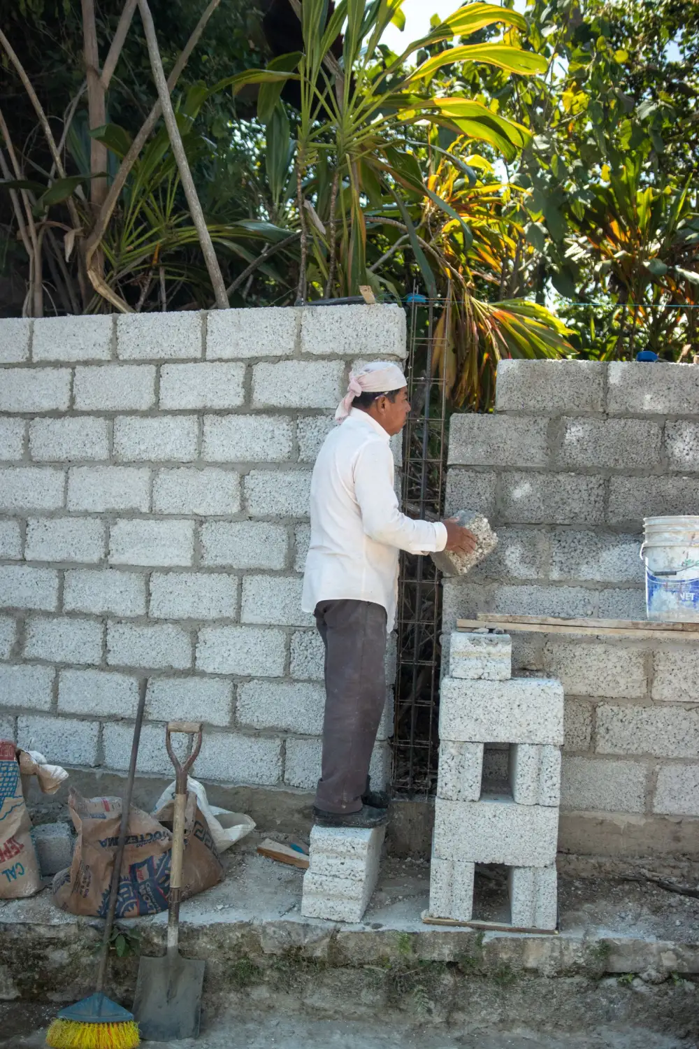 Alba&ntilde;il colocando block en el levantado de un muro