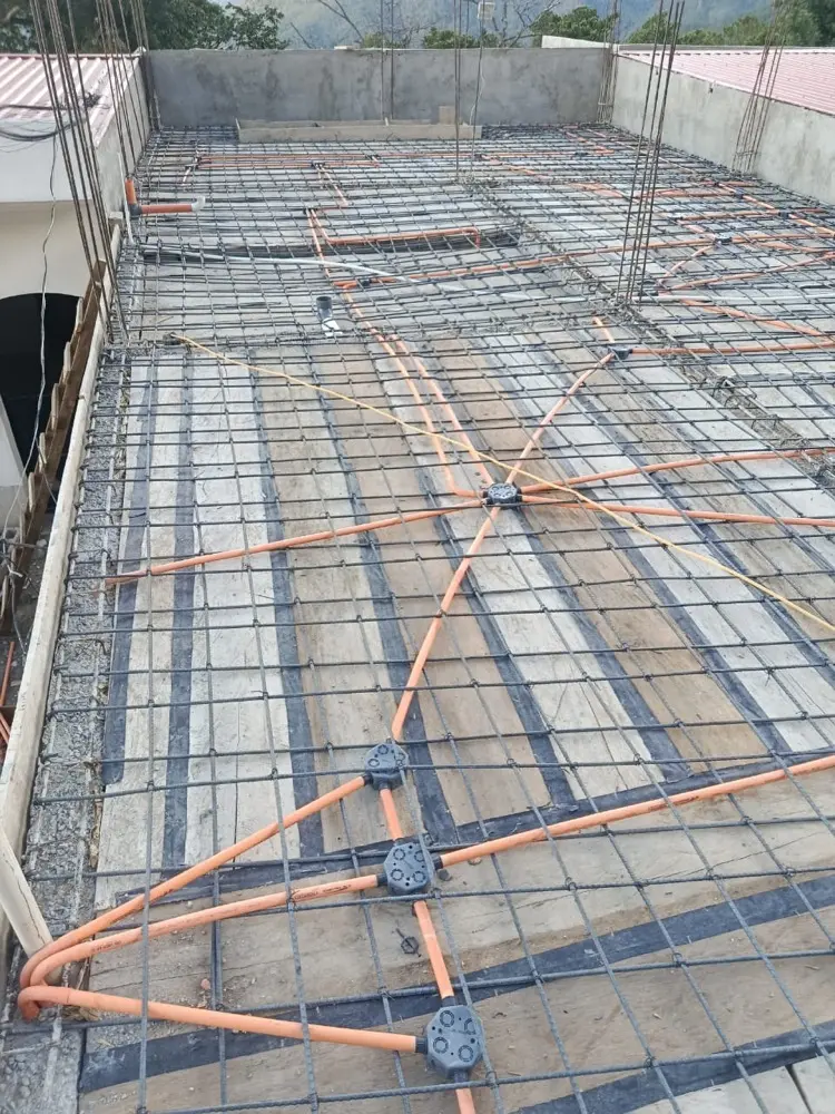 Tuber&iacute;a el&eacute;ctrica naranja y cajas distribuidas en el armado de una losa