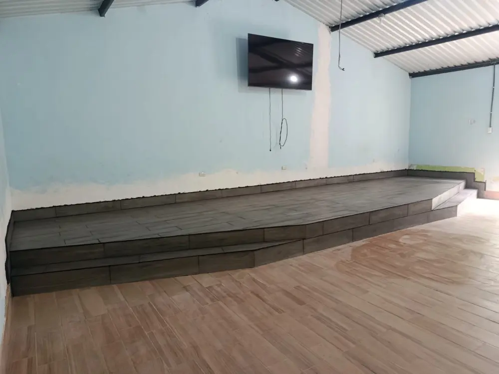 Vista lateral de la plataforma de cer&aacute;mica a lo largo del sal&oacute;n, con su grada de acceso
